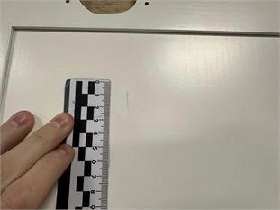 Измерительная шкала рядом с царапиной на мебельном фасаде